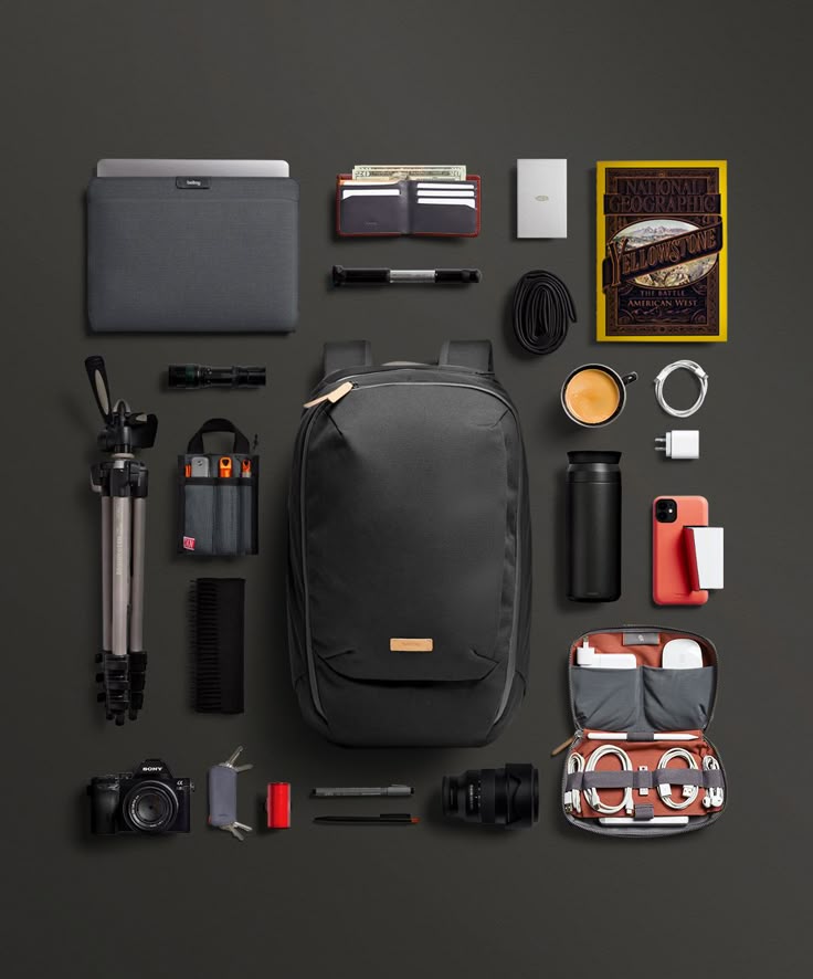 Flat lay of budget travel essentials including bag, pouches, and gadgets for trips